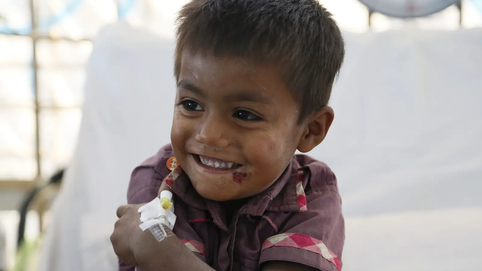 A smiling four-year-old Rohingya boy after medical treatment